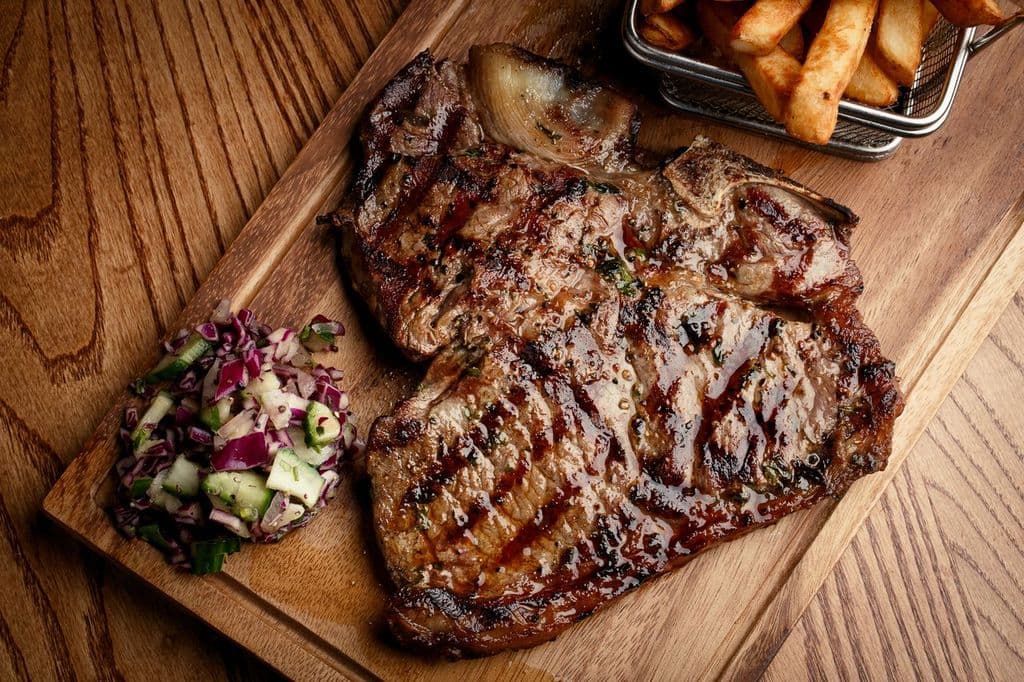 Sizzling steak served with sides at Cattle Steakhouse