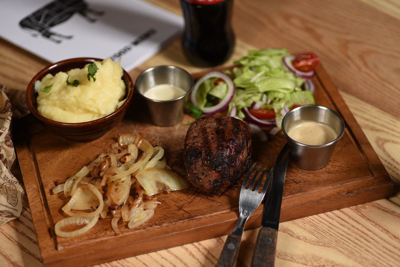 Steak served with fried egg and mushrooms